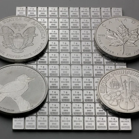 100g Silbertafel neben 1oz Silbermünzen